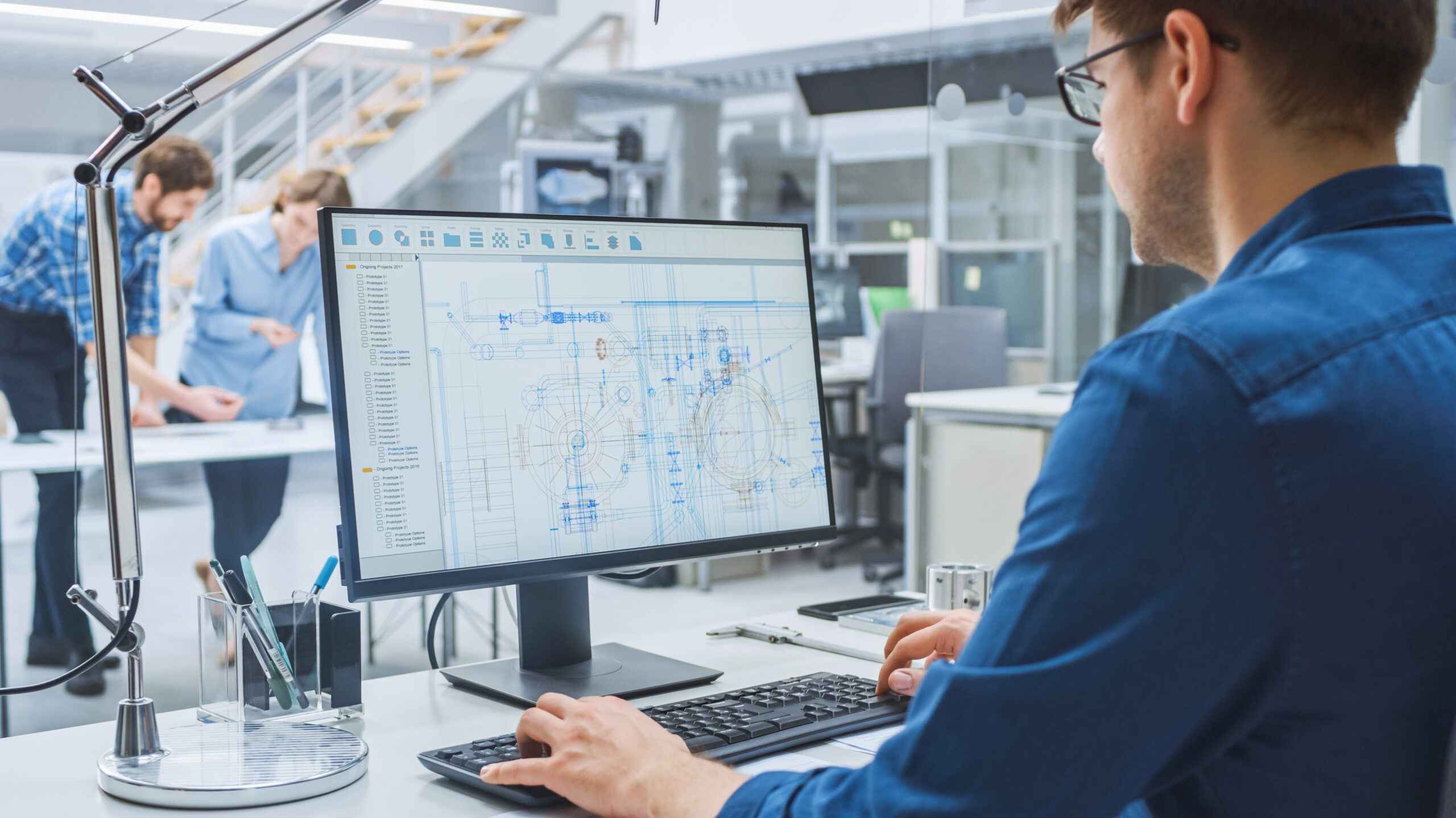 Ingénieur concevant un projet industriel sur logiciel de CAO dans un bureau d’études